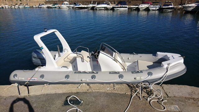 Barco semirrígido amarrado en Porto Senso, Altea, listo para el alquiler y la aventura.